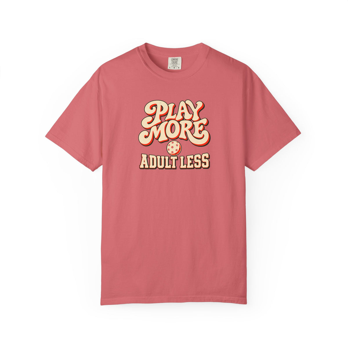 Watermelon colored Play More Adult Less pickleball t-shirt with playful cream script typography.