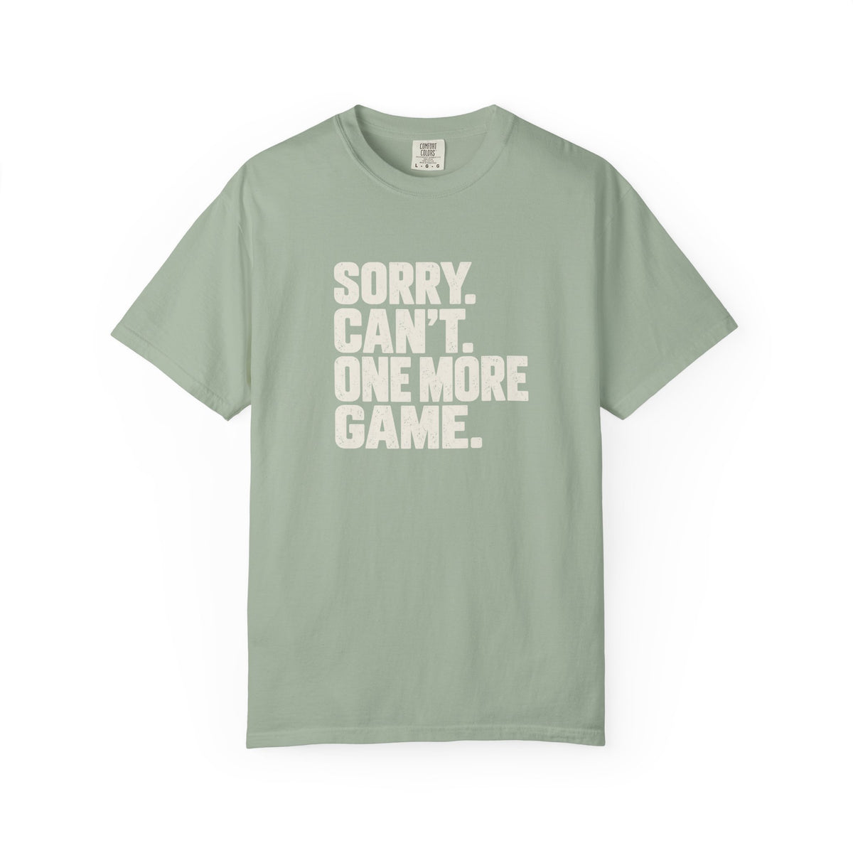 Sage colored Sorry. Can't. One More Game. pickleball t-shirt with bold stacked cream typography.