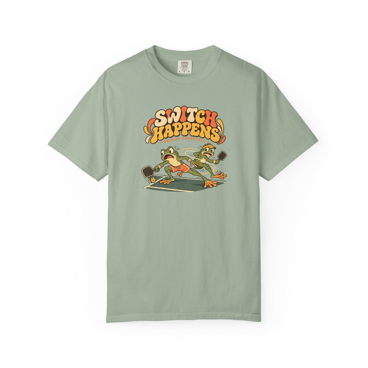 Sage colored Switch Happens pickleball t-shirt with colorful retro court graphic and bold curved lettering.