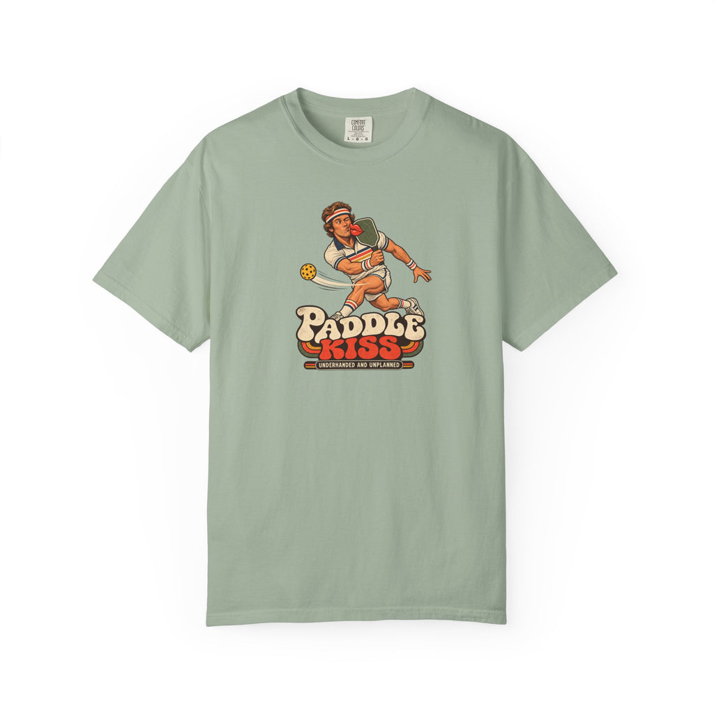 Sage colored Paddle Kiss pickleball t-shirt with playful vintage paddle-and-pickleball character graphic.