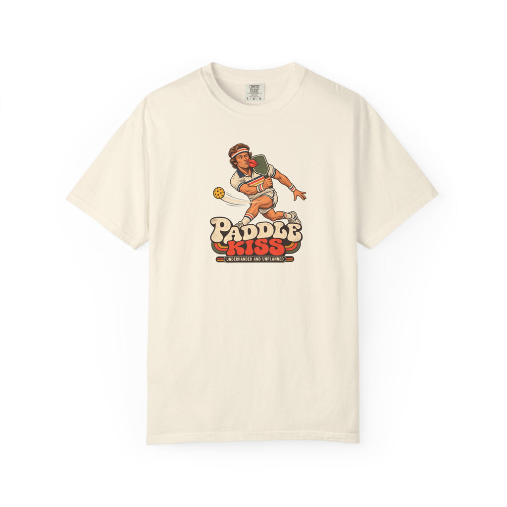 Ivory colored Paddle Kiss pickleball t-shirt with playful vintage paddle-and-pickleball character graphic.