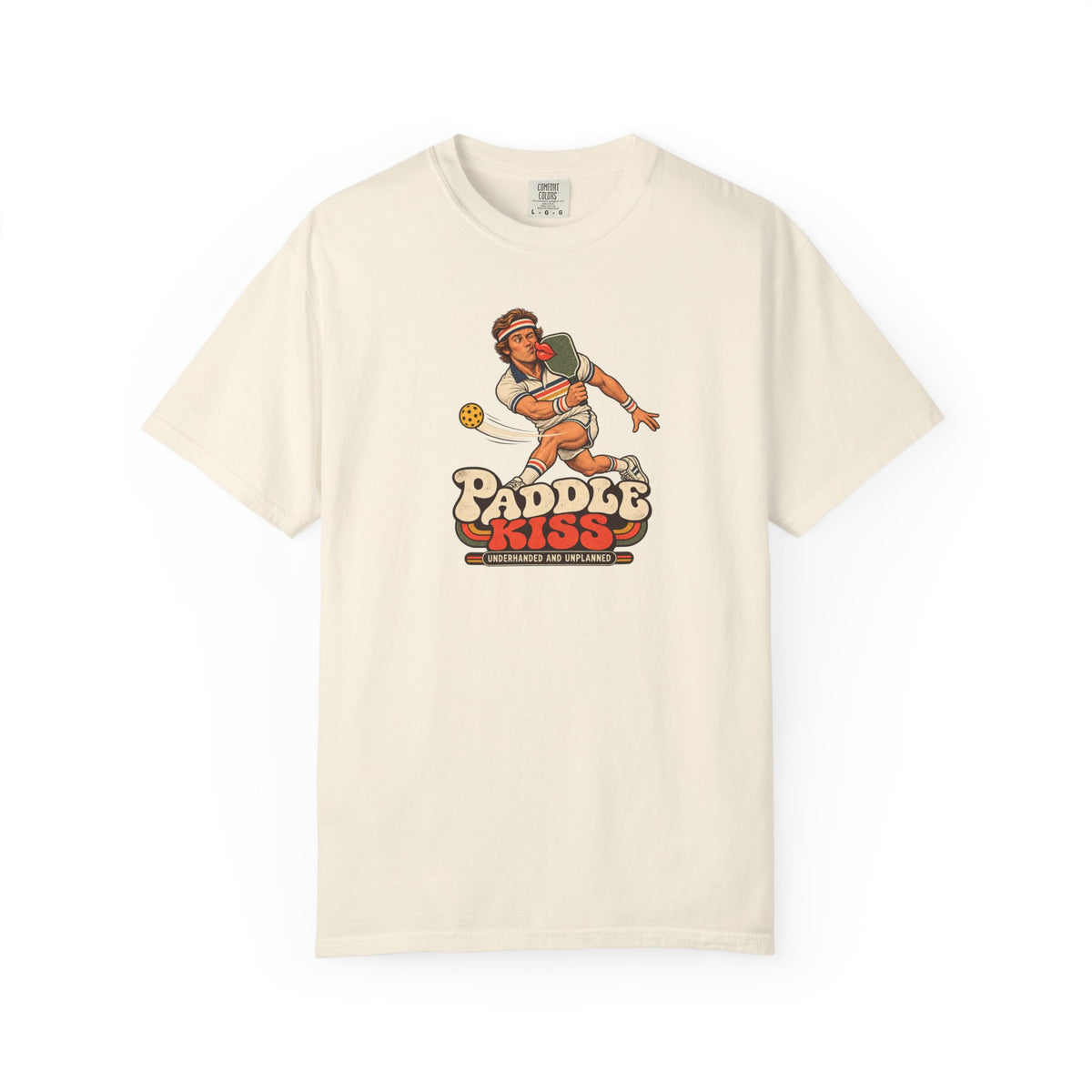 Ivory colored Paddle Kiss pickleball t-shirt with playful vintage paddle-and-pickleball character graphic.