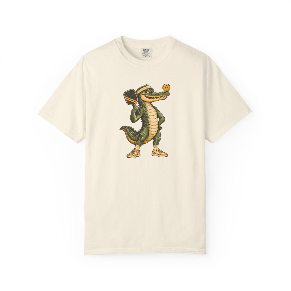 Ivory colored Pickleball Gator pickleball t-shirt with cartoon alligator player holding a paddle.