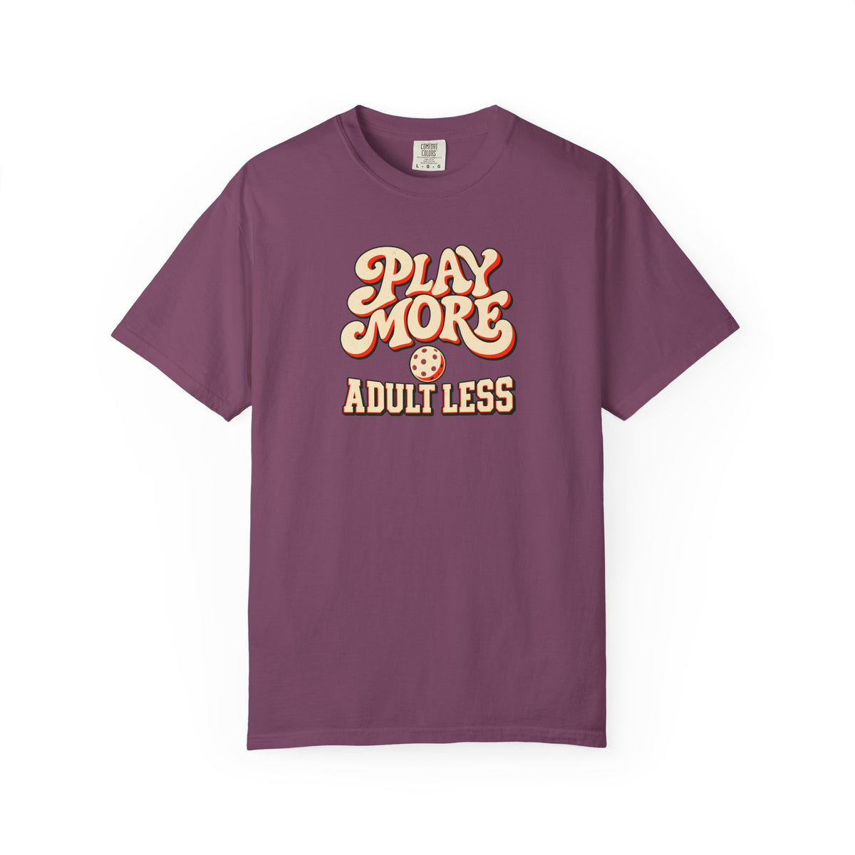 Berry colored Play More Adult Less pickleball t-shirt with playful cream script typography.