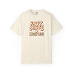 Ivory colored Play More Adult Less pickleball t-shirt with playful cream script typography.