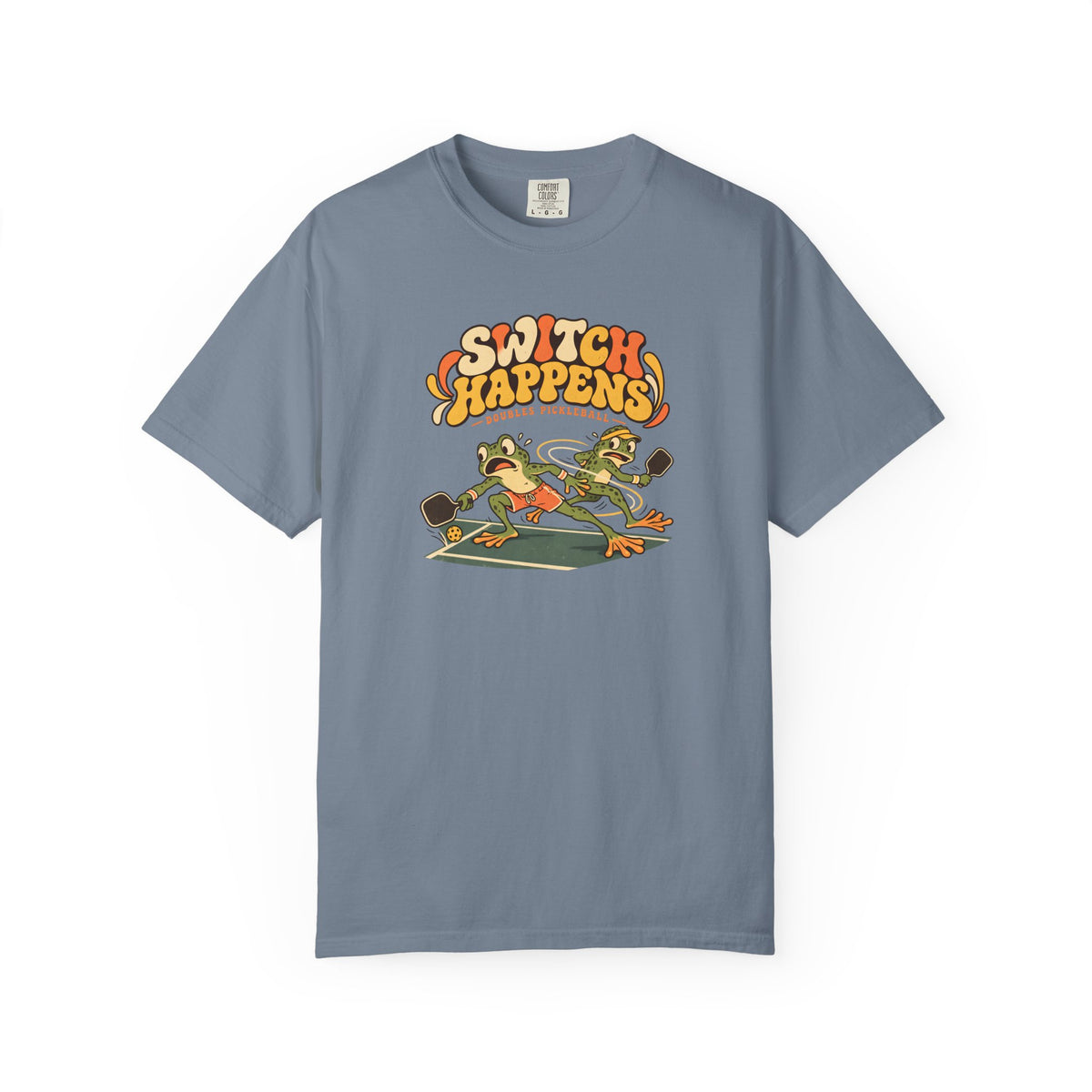 Blue-gray colored Switch Happens pickleball t-shirt with colorful retro court graphic and bold curved lettering.