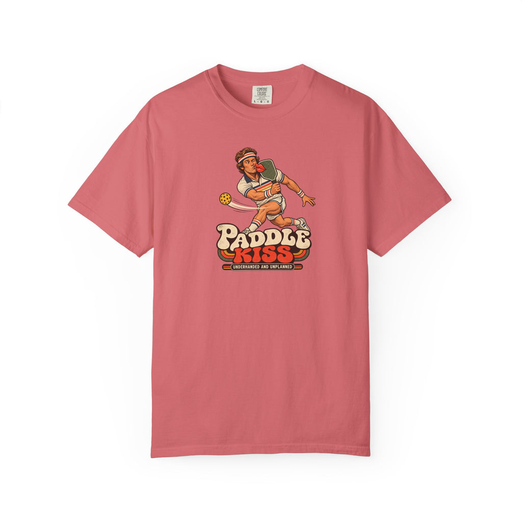 Watermelon colored Paddle Kiss pickleball t-shirt with playful vintage paddle-and-pickleball character graphic.