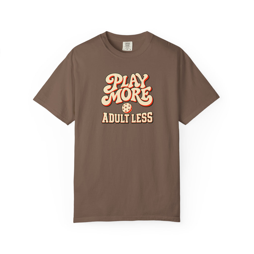 Espresso colored Play More Adult Less pickleball t-shirt with playful cream script typography.
