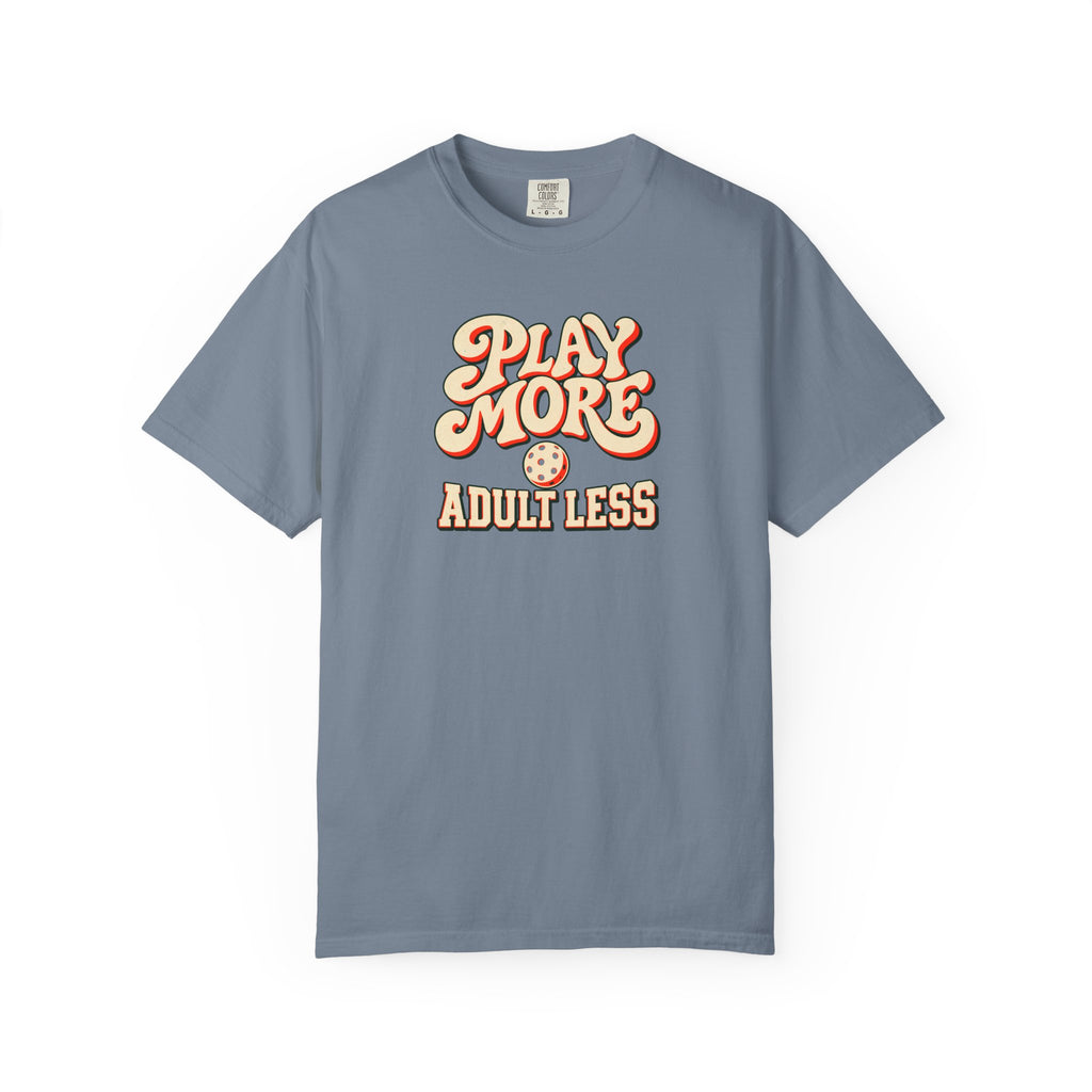 Blue-gray colored Play More Adult Less pickleball t-shirt with playful cream script typography.
