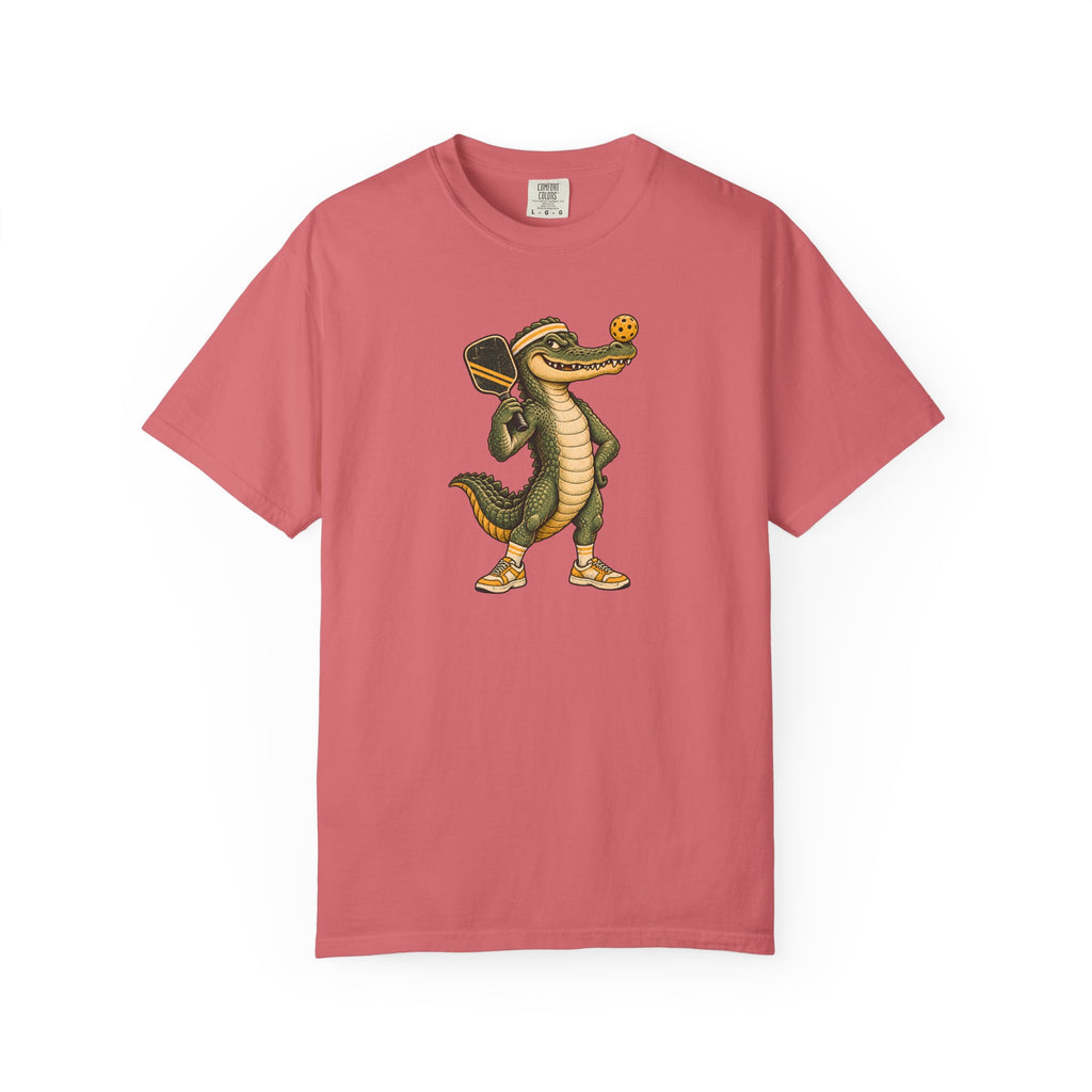Watermelon colored Pickleball Gator pickleball t-shirt with cartoon alligator player holding a paddle.