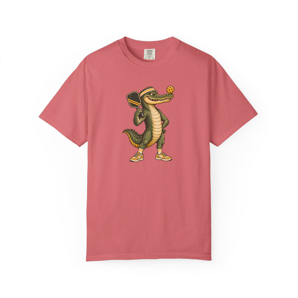 Watermelon colored Pickleball Gator pickleball t-shirt with cartoon alligator player holding a paddle.